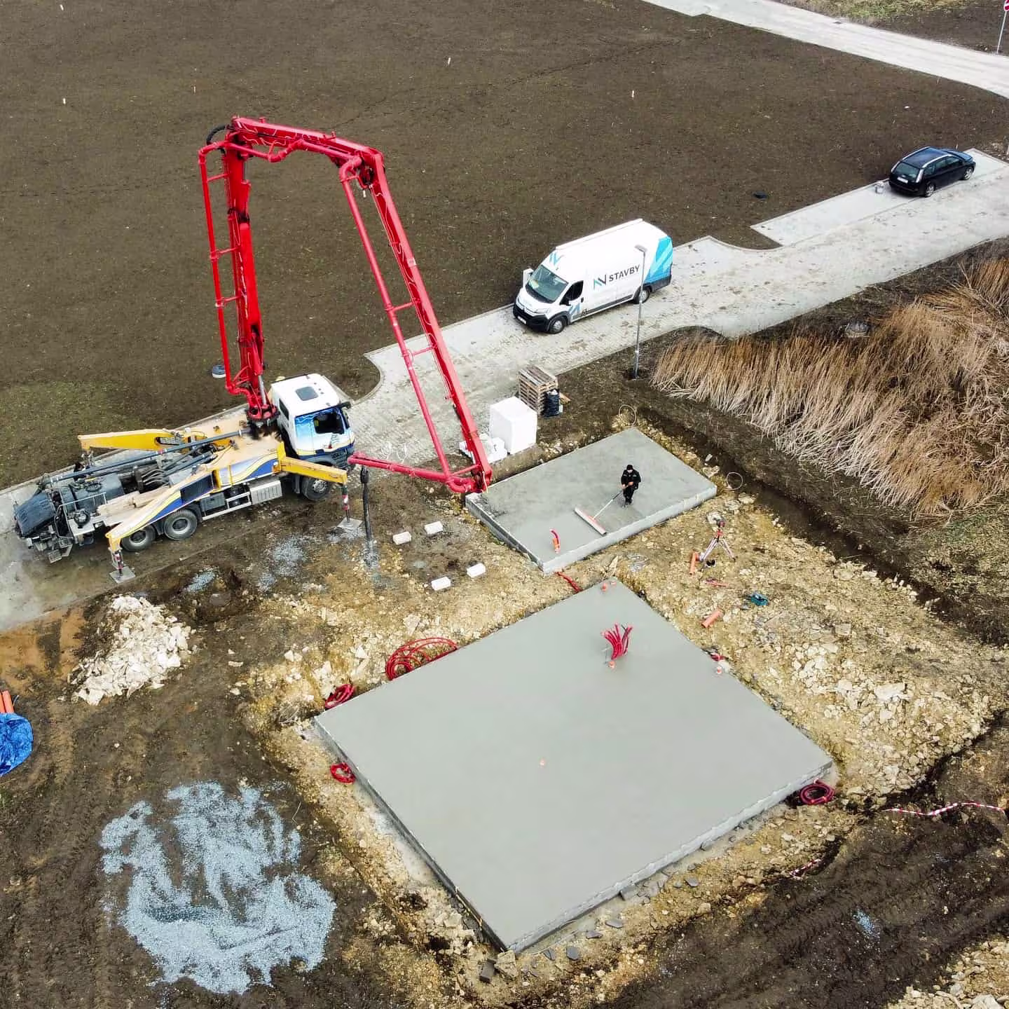 Betonáž základové desky v Dolanech u Kladna s pomocí čerpadla na beton. Stavební firma NNstavby realizuje finální fázi základů pro rodinný dům.