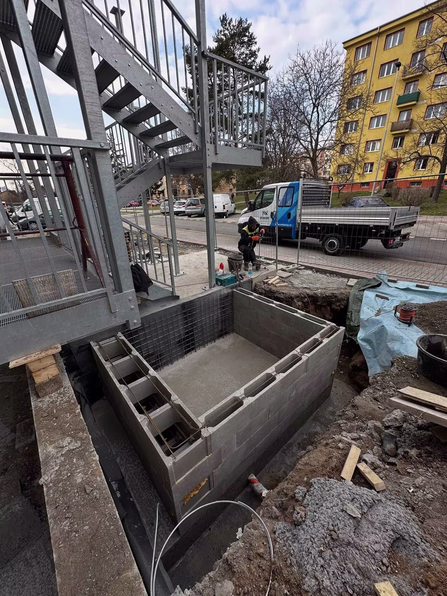 Stavba základů pro výtahovou šachtu s využitím betonových tvárnic a bednění.