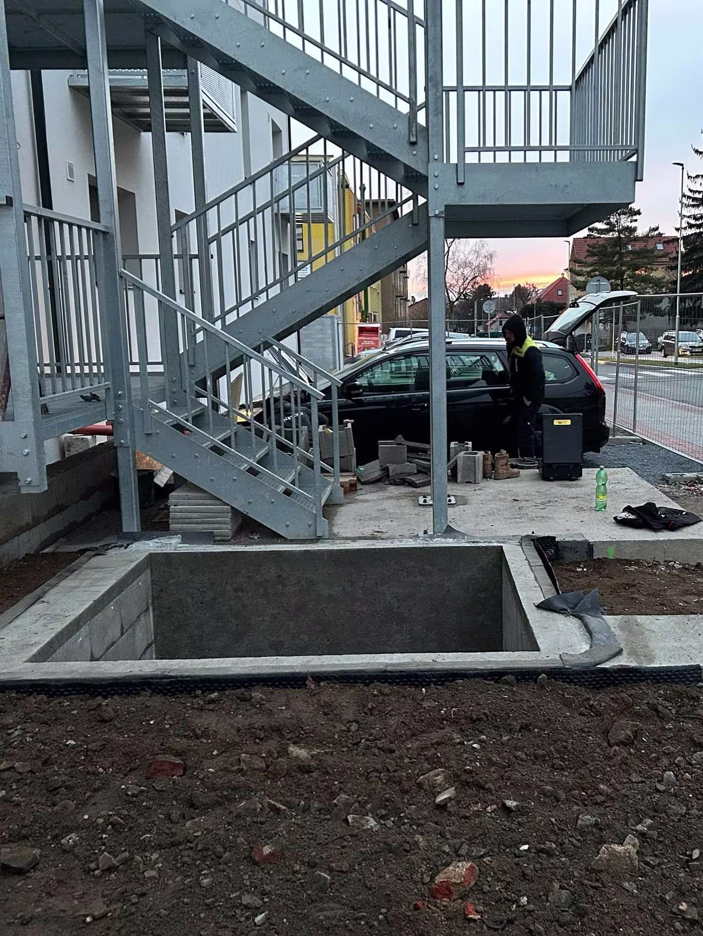 Hotová a zasypaná betonová základová vana připravená pro montáž ocelové konstrukce výtahu.