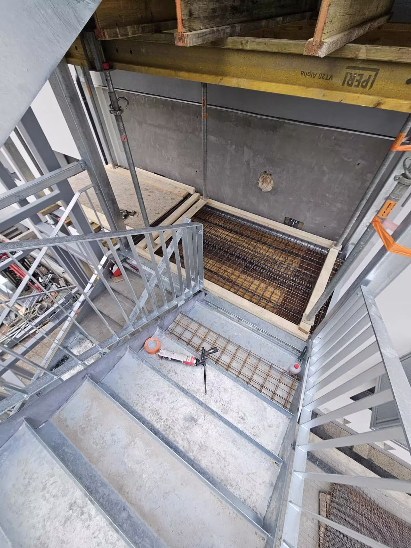 Pohled shora na montovanou ocelovou konstrukci a přípravu armování pro betonáž podesty v Praze - Hloubětíně.