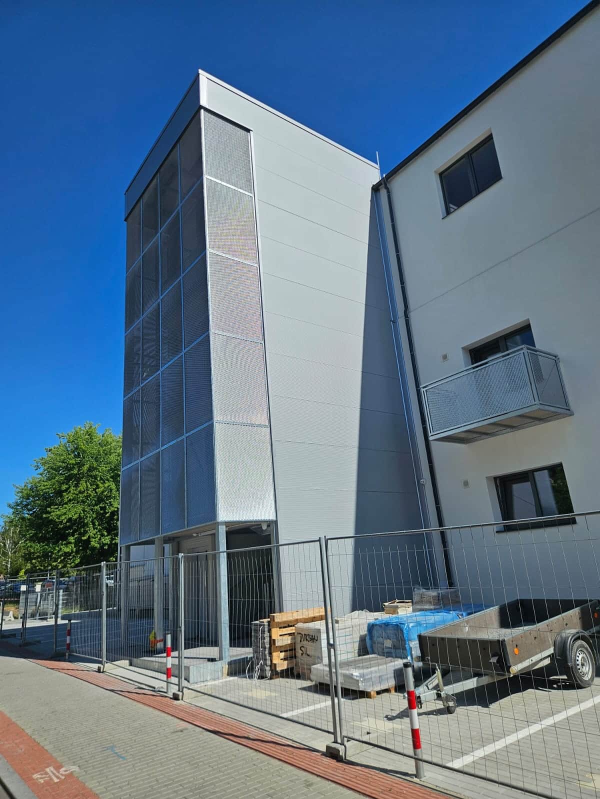 Finální podoba dokončené externí výtahové šachty s moderním děrovaným plechovým opláštěním v Praze - Hloubětíně.