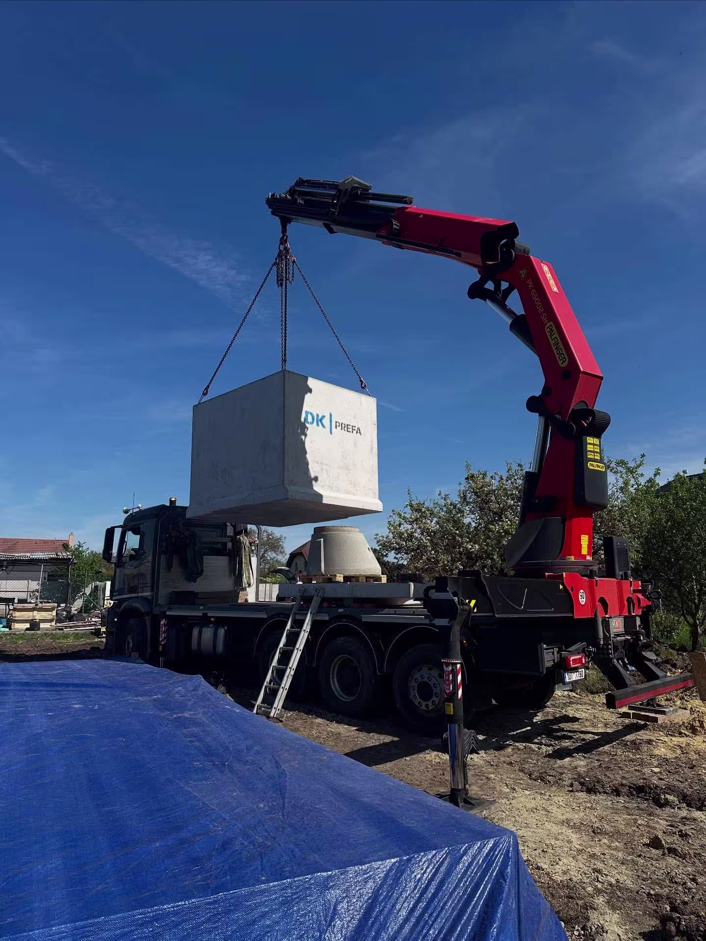 Manipulace s betonovou jímkou 10 m3 pomocí hydraulického jeřábu před jejím usazením do výkopu.