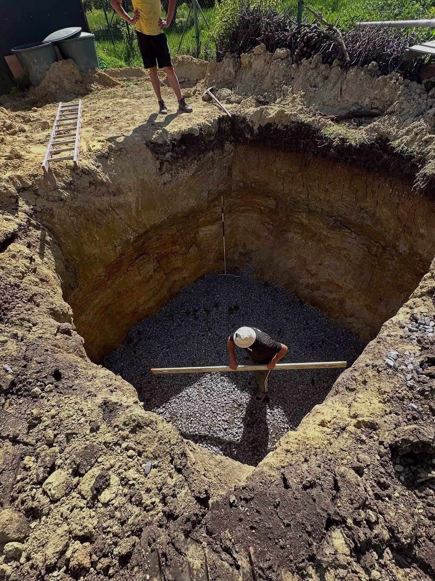 Příprava štěrkového podloží na dně výkopu, která zajistí stabilitu pro betonovou jímku.