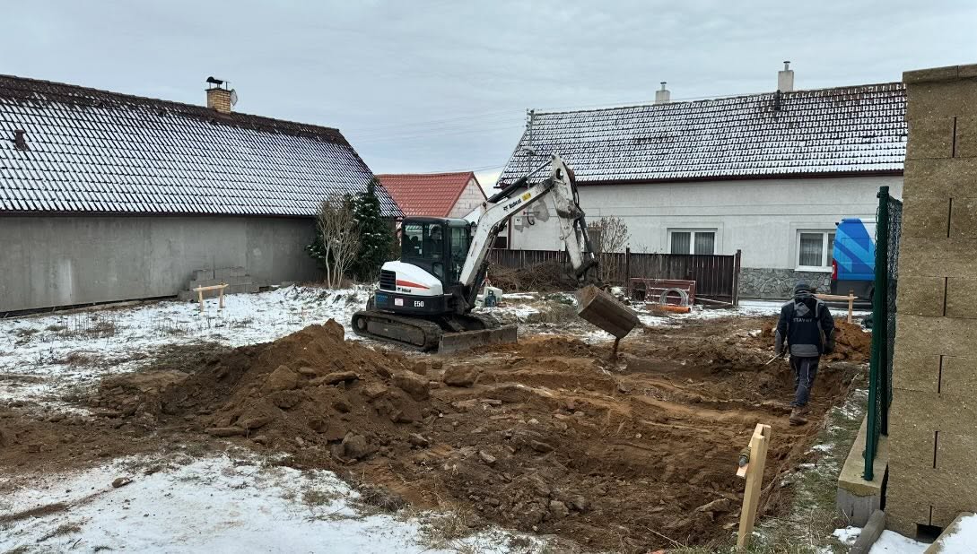 Výkopové práce a rovnání terénu bagrem po demolici původního objektu v Brodcích v realizaci nnstavby.