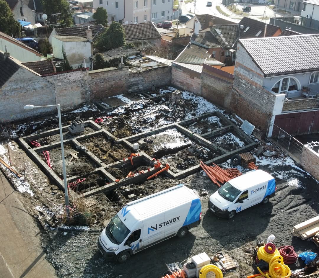 Rozestavěné základové pasy a technika firmy nnstavby na staveništi v pražských Třeboradicích.
