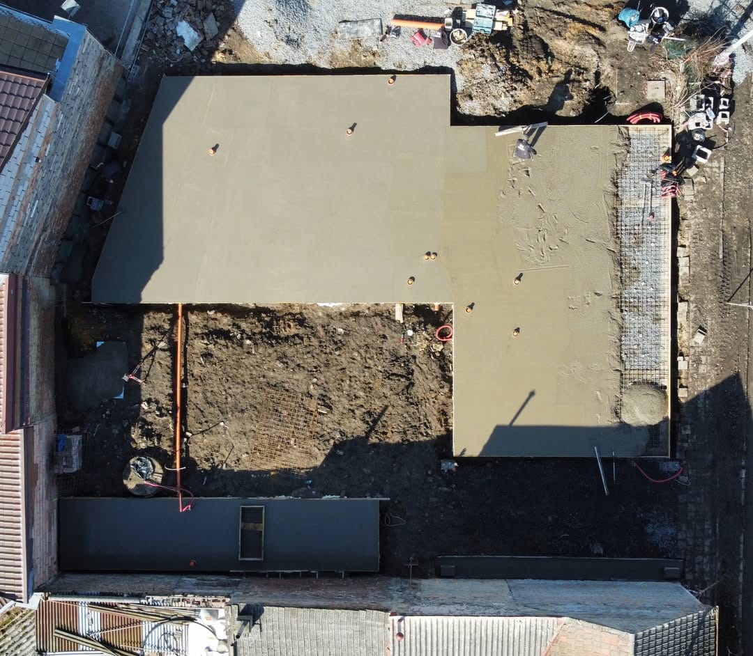 Pohled na vylitou základovou desku o ploše 200 m2 pro novostavbu v Třeboradicích od nnstavby.